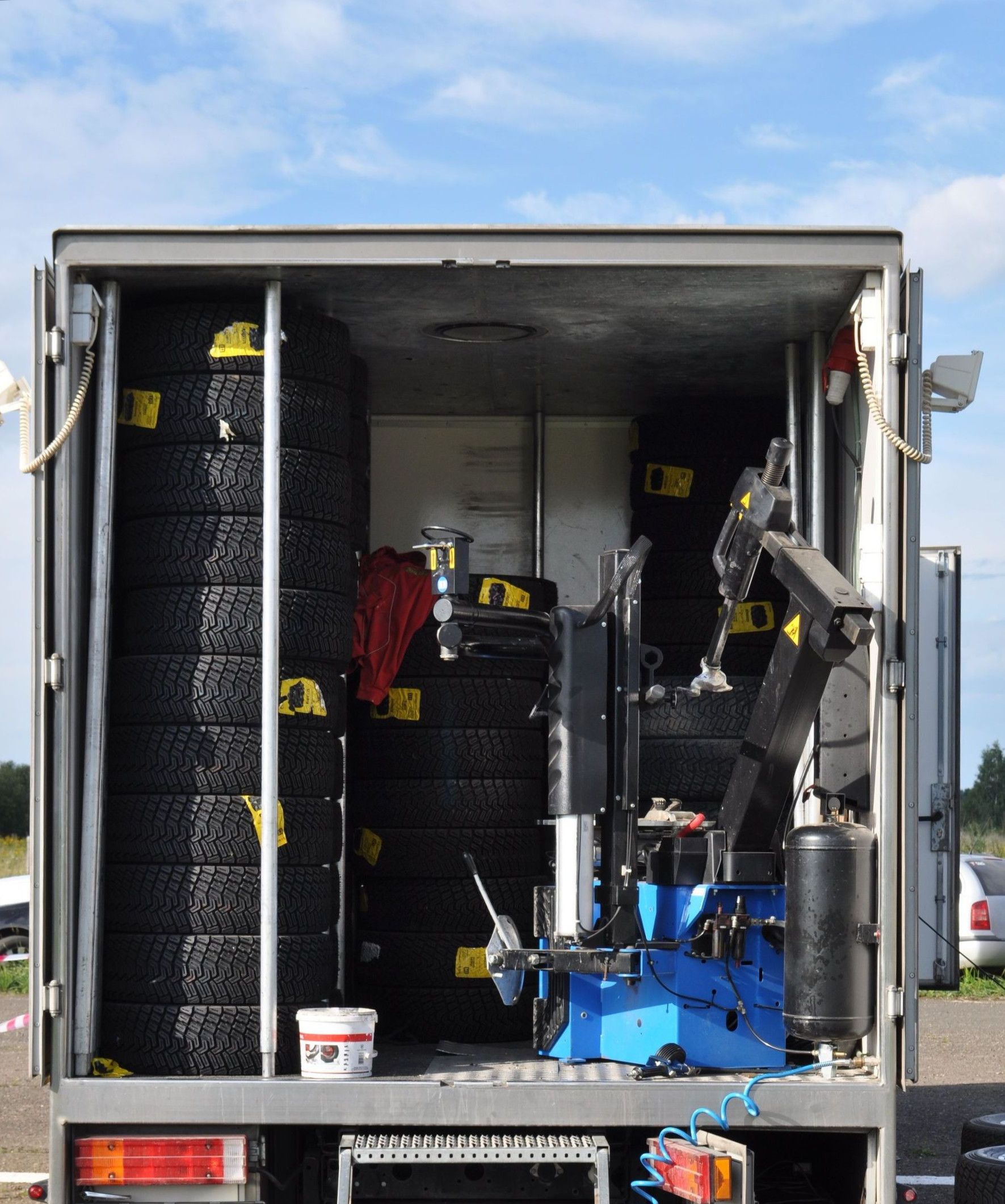A mobile tire repair truck stocked with tires and machinery for roadside assistance.
